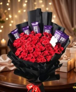 Romantic bouquet of red roses and chocolates wrapped in elegant black paper