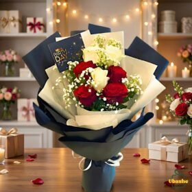 Red and white rose bouquet wrapped in elegant navy and cream paper, beautifully arranged for gifting in Pakistan.