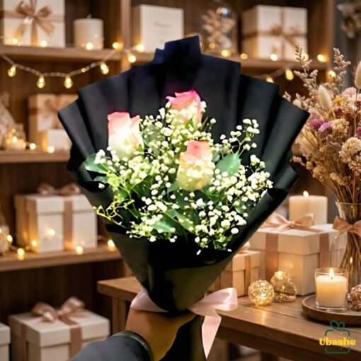 Elegant rose bouquet wrapped in black paper with baby’s breath, displayed in a gift shop setting