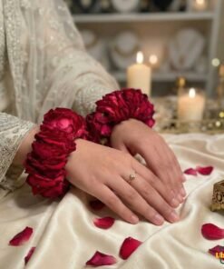 Bride wearing fresh red rose gajray on hands, traditional Pakistani wedding floral jewellery
