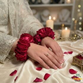 Bride wearing fresh red rose gajray on hands, traditional Pakistani wedding floral jewellery